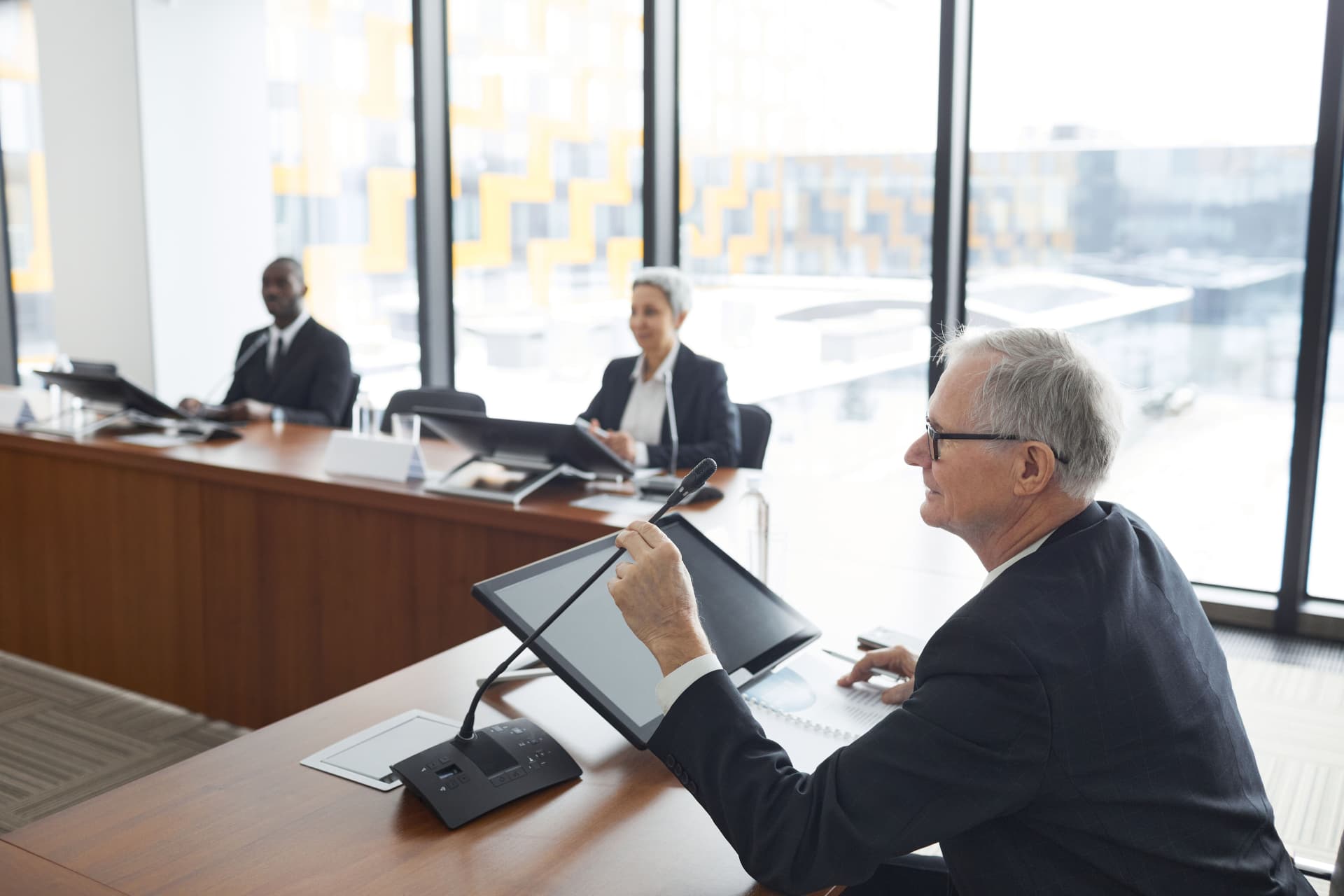 Attorneys and advisors seated at a conference table during a formal session.